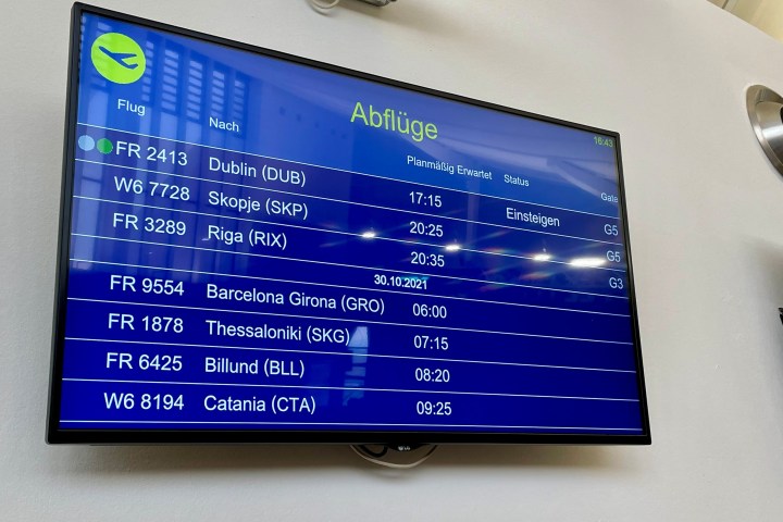 Airport departures board displaying flight information.